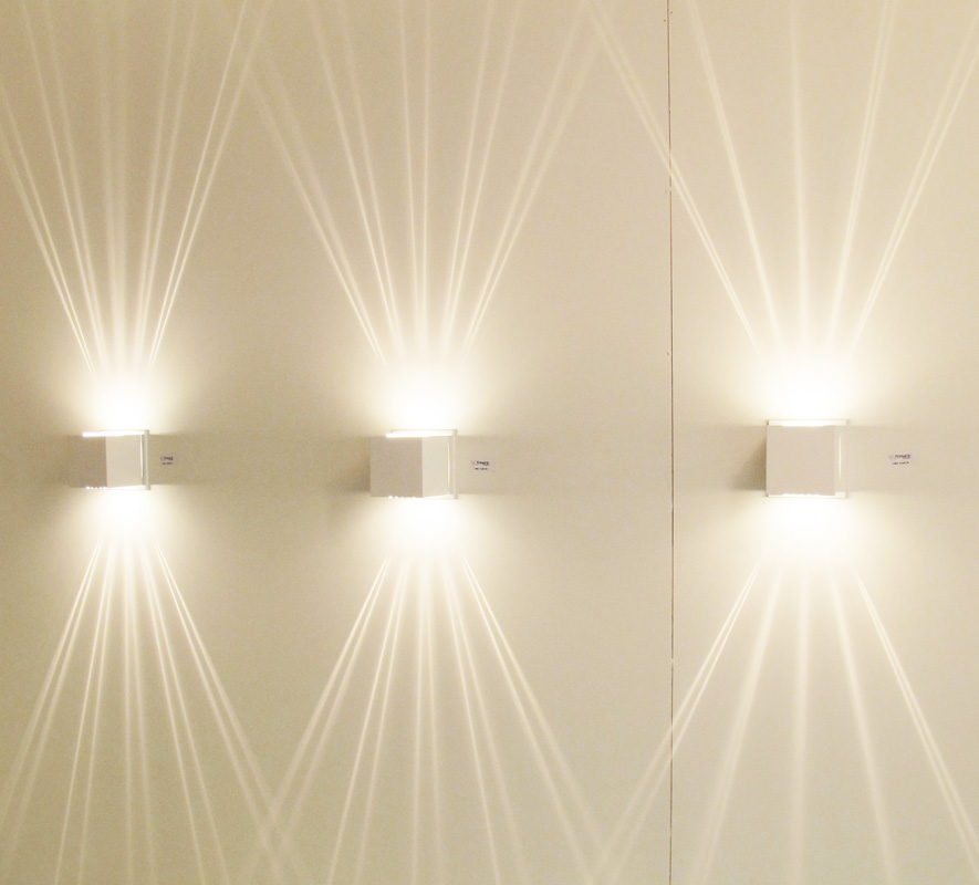 Iluminação de arandelas decorativas traçando raios de luz em parede, dando um ótimo efeito de iluminação