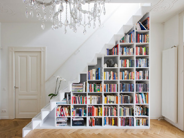 Espaço da escada sendo usado como prateleira de livros